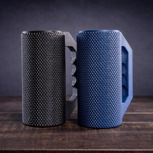 Peut inclure: Deux tasses cylindriques avec une surface ext&eacute;rieure textur&eacute;e &agrave; motif en losange. Une tasse est noir mat et l'autre est bleu mat. Chacune pr&eacute;sente une poign&eacute;e solide et angulaire avec des rainures pour les doigts sur le c&ocirc;t&eacute; int&eacute;rieur.