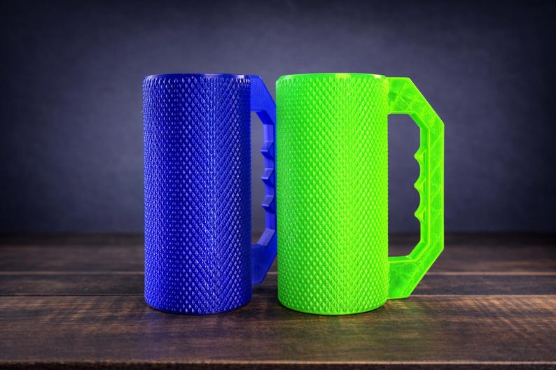 Peut inclure: Deux tasses cylindriques avec une surface textur&eacute;e &agrave; motif de losanges. Une tasse est bleu vif et l'autre est vert n&eacute;on. Chaque tasse pr&eacute;sente une poign&eacute;e angulaire robuste avec un design dentel&eacute; sur le bord int&eacute;rieur pour la prise.