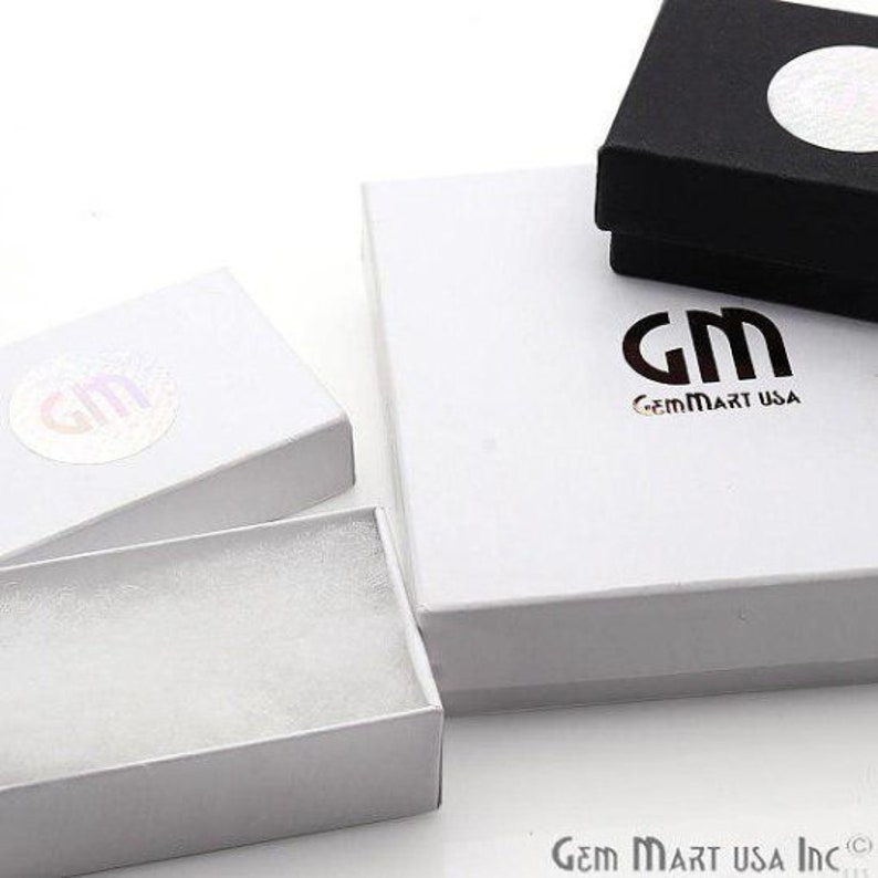 May include: Three white gift boxes with a black gift box. The white boxes have the logo "GM GemMart USA" printed on them. The black box has a white circle on the top.