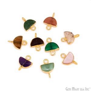 May include: A collection of nine semi-circular gemstone charms set in gold-toned metal frames. Each charm features a different stone, including green, brown, black, purple, and pink varieties, with small circular loops at the top and bottom for attachment.