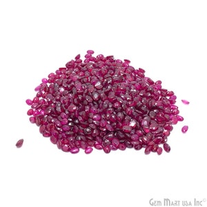 May include: A large pile of loose oval-shaped ruby gemstones. The rubies are a deep red color and have a glossy finish.