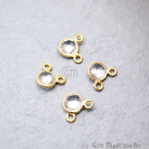 May include: Four clear crystal gemstone connector charms with gold-plated settings. Each charm has two loops for attaching to jewellery.