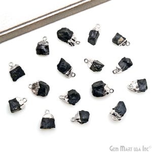 May include: A collection of 15 black gemstone pendants with silver accents. The pendants are all different shapes and sizes, and they are arranged in a random pattern on a white surface.