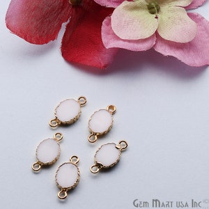 May include: Five white oval-shaped connector charms with gold-toned metal accents. Each charm has two loops for attaching to jewelry.