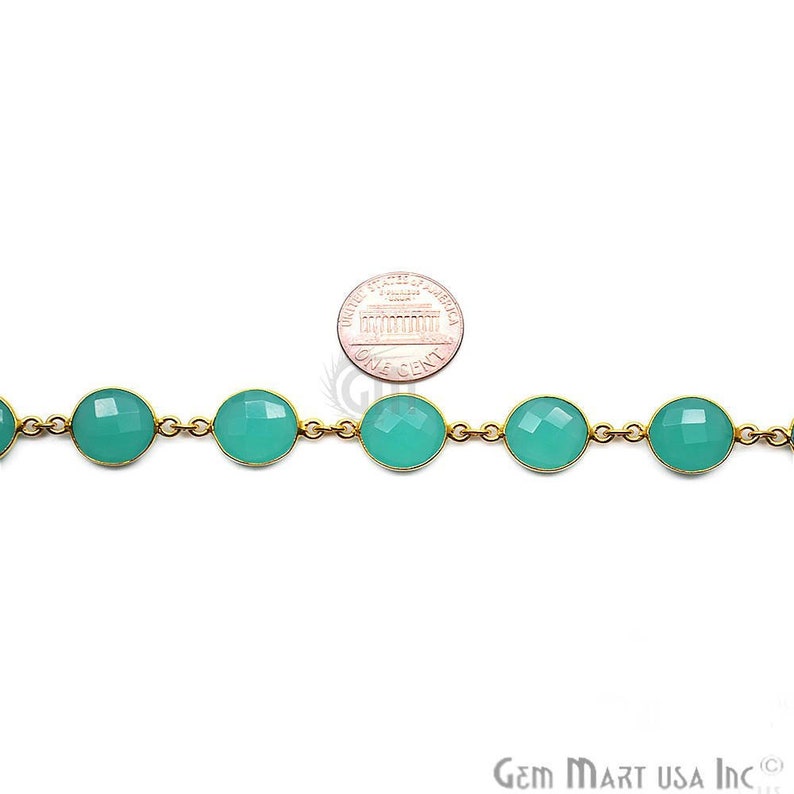 May include: A gold chain with round, teal-colored gemstone beads. The chain is shown next to a US penny for size comparison. Gem Mart USA Inc. is printed on the bottom right corner of the image.