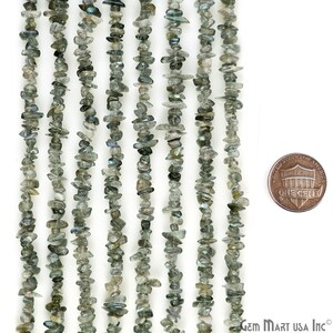 May include: A strand of grey and black chip labradorite beads, approximately 16 inches long, with a penny for scale.