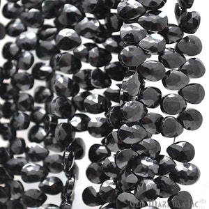 May include: A strand of black faceted gemstone beads in a teardrop shape.