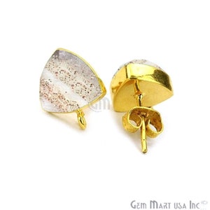 Peut inclure: Une paire de boucles d'oreilles à clous dorées. Chaque boucle d'oreille présente une pierre transparente triangulaire avec des inclusions brun rougeâtre, sertie dans une lunette dorée. Les boucles d'oreilles ont un fermoir à poussoir et papillon.
