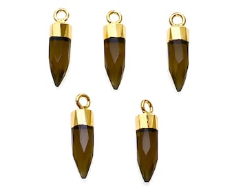 Puede incluir: Cinco colgantes chapados en oro con una piedra preciosa marrón oscura en forma de lágrima puntiaguda. Los colgantes están diseñados para ser utilizados en la fabricación de joyas.