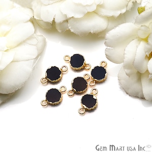May include: Six gold-toned metal connector charms with black round glass inlays. Each charm has two loops for attaching jewelry.