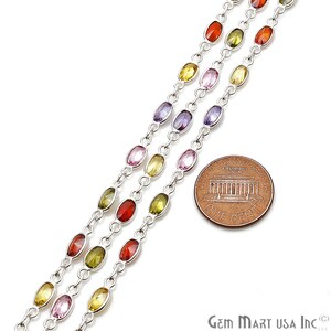May include: Three strands of silver chain with oval-shaped gemstones in various colors, including red, orange, yellow, green, purple, and pink. The chain is next to a US penny for scale.