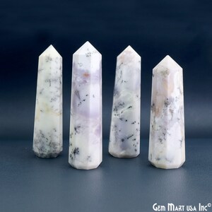 Pode incluir: Quatro torres de pedra polida com pontas hexagonais, apresentando uma base branca leitosa com tons de lavanda e inclusões dendríticas escuras. As pedras têm um acabamento liso e semitranslúcido. O texto Gem Mart USA Inc é visível no canto.