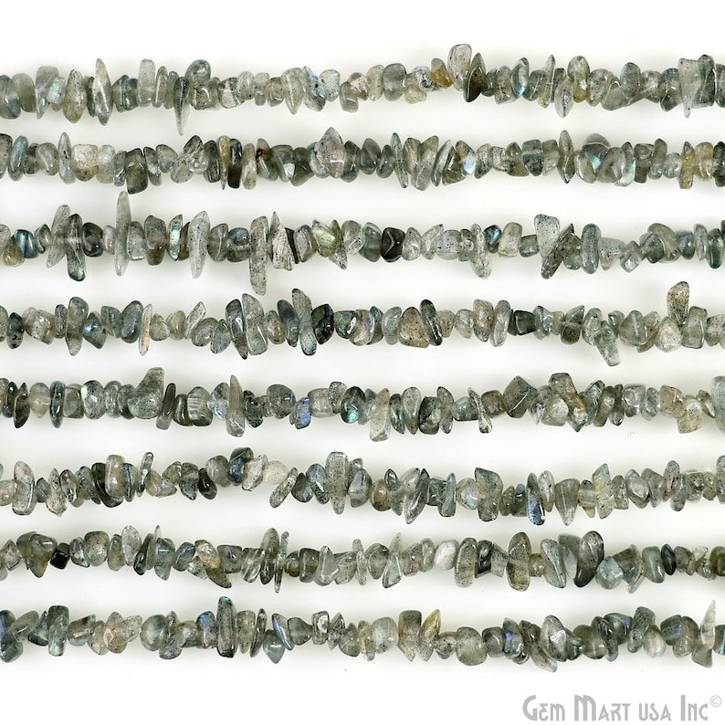 May include: A strand of gray and black labradorite chip beads. The beads are irregular in shape and size, with a slightly iridescent sheen.