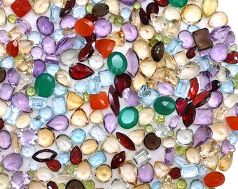 May include: A large collection of loose, faceted gemstones in various shapes and sizes, including round, oval, pear, square, and marquise cuts. The stones feature a diverse color palette of red, green, purple, light blue, yellow, and clear tones.