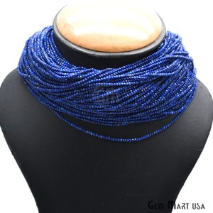 May include: A long strand of deep blue lapis lazuli beads, strung together to form a necklace. The beads are small and uniform in size, creating a smooth and elegant look.