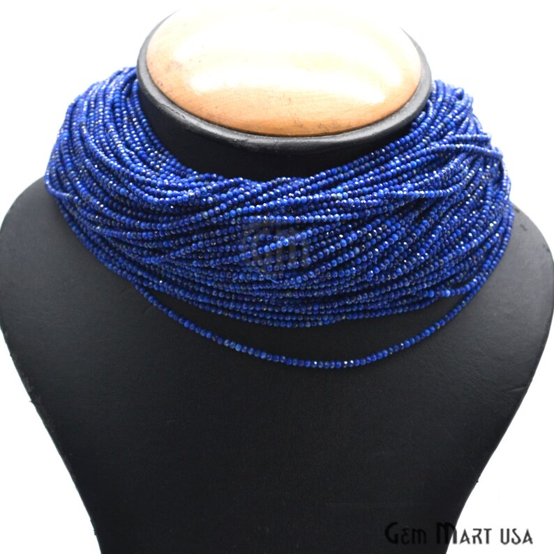 May include: A long strand of deep blue lapis lazuli beads, strung together to form a necklace. The beads are small and uniform in size, creating a smooth and elegant look.