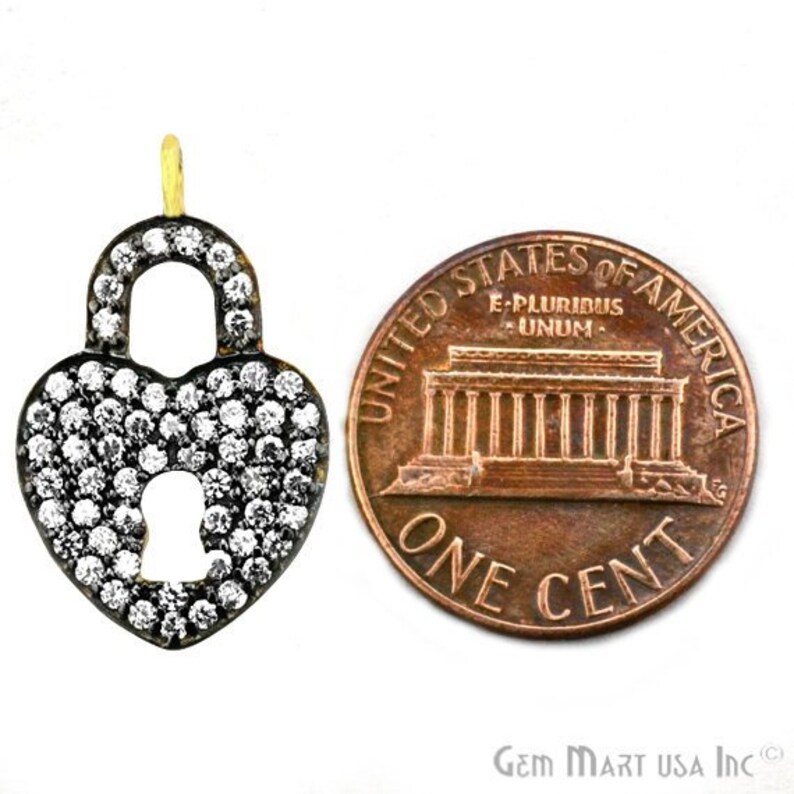 May include: A silver heart-shaped padlock charm with a clear crystal design. The charm is about the size of a US penny.