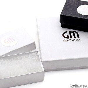 K&ouml;nnte beinhalten: Eine Sammlung wei&szlig;er und schwarzer Schmuckschatullen. Die rechteckigen Schachteln tragen das Logo "GM" und "GemMart USA". Eine Schachtel ist ge&ouml;ffnet und zeigt einen wei&szlig;en Innenraum.