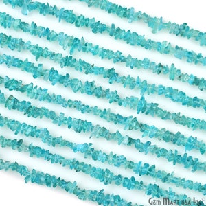 Pode incluir: Um fio de contas de chip de água-marinha azul claro. As contas são pequenas e irregulares na forma, e são enfiadas em um fio transparente. As contas são dispostas em linha reta, e todas são do mesmo tamanho. As contas são de cor azul claro, e têm um brilho ligeiramente iridescente.