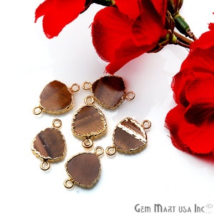 May include: Six brown tiger's eye gemstone pendants with gold-plated edges and jump rings. The pendants are irregularly shaped and have a natural, organic look.