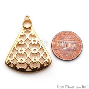 May include: Gold-tone metal pendant with a decorative, intricate, geometric design. The pendant is shaped like a triangle with rounded edges and has a small hole at the top for hanging. The pendant is about the size of a US penny.