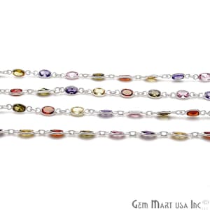May include: A silver chain with colorful oval-shaped gemstones. The chain features a repeating pattern of purple, pink, yellow, orange, and green gemstones.