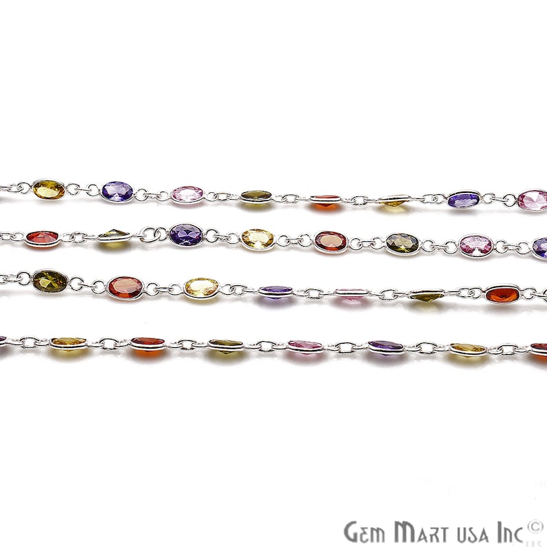 May include: A silver chain with colorful oval-shaped gemstones. The chain features a repeating pattern of purple, pink, yellow, orange, and green gemstones.
