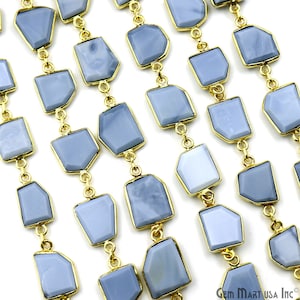 May include: A strand of light blue gemstone beads with gold-toned metal connectors. The beads are irregularly shaped and have a slightly cloudy appearance.