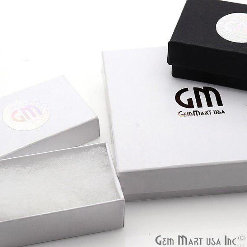 May include: Three white gift boxes with a black box in the background. The white boxes have a logo that says "GemMart USA".