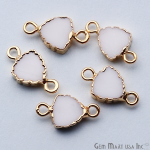 May include: Five gold-tone metal triangle-shaped charms with white enamel. Each charm has two loops for attaching to jewelry.