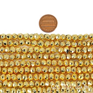 May include: Close-up of strands of faceted, golden-colored beads. A U.S. one-cent coin is placed above the beads for size comparison. The beads have a metallic sheen and are arranged in neat rows, suggesting jewelry making supplies.