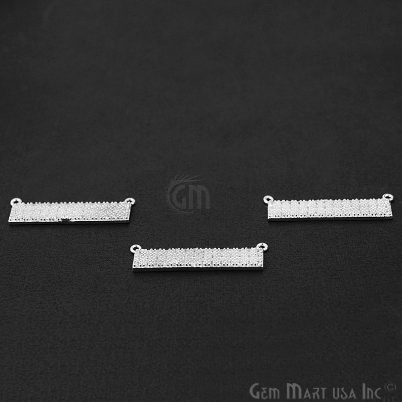 May include: Three silver-toned rectangular bar pendants with clear crystal embellishments. The pendants have two jump rings on each side for attaching to a chain or cord.