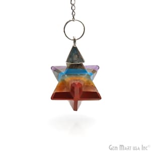 May include: A seven-chakra crystal pendulum with a silver chain. The pendulum is shaped like a star and is made of seven different colored crystals. The crystals are arranged in a circle around the center of the star. The pendulum is hanging from a silver chain.