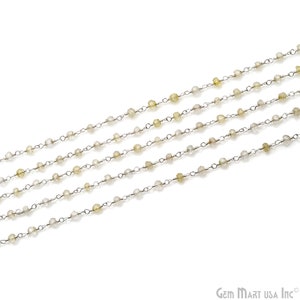 May include: Five strands of silver chain with small, clear and yellow faceted beads.
