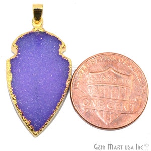 May include: Purple agate arrowhead pendant with a gold-plated edge. The pendant is about the size of a US penny.