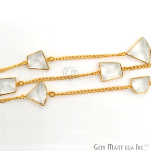 Pu&ograve; includere: Una collana a catena dorata con accenti di pietre preziose di quarzo trasparente. La catena &egrave; realizzata con piccoli cerchi collegati e le pietre preziose sono sfaccettate e hanno una forma rettangolare o triangolare.