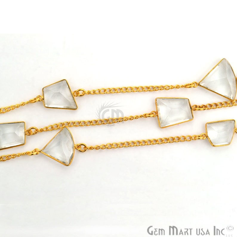 Pu&ograve; includere: Una collana a catena dorata con accenti di pietre preziose di quarzo trasparente. La catena &egrave; realizzata con piccoli cerchi collegati e le pietre preziose sono sfaccettate e hanno una forma rettangolare o triangolare.