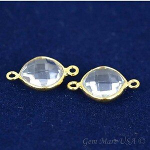 Puede incluir: Dos abalorios conectores de tono dorado con piedras de cristal facetadas transparentes. Cada abalorio tiene dos anillos de salto para sujetar a las joyas.