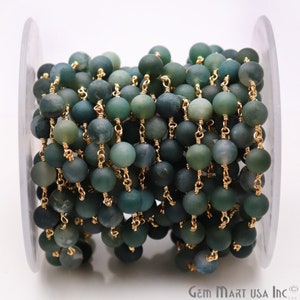 May include: A spool of green agate beads strung on a gold chain. The beads are round and have a matte finish. The chain is delicate and has a gold finish.