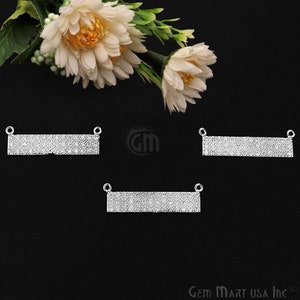 May include: Three silver-toned rectangular bar pendants with a sparkly, crystal-like finish. Each pendant has two small loops at the top for attaching to a chain or cord.