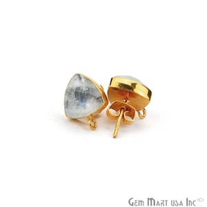 Puede incluir: Un par de pendientes de botón dorados con una piedra preciosa triangular e iridiscente. Las piedras preciosas están engastadas en un bisel dorado. Los pendientes tienen un cierre de poste y mariposa.