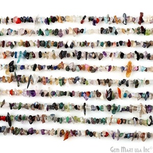 May include: A strand of mixed gemstone chips, featuring a variety of colours and shapes. The chips are small and irregular, and they are strung together on a clear thread. The strand is approximately 16 inches long.