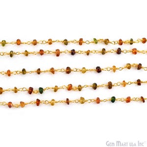 May include: A gold-toned wire-wrapped chain featuring small, irregular, multi-coloured gemstone beads in shades of amber, brown, and green. The chain is arranged in five horizontal rows, showcasing a delicate link design with evenly spaced stones.