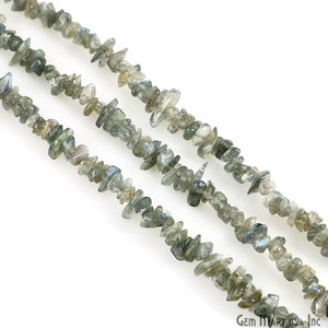 May include: A strand of grey and blue labradorite chip beads. The beads are irregular in shape and have a natural, rough texture.