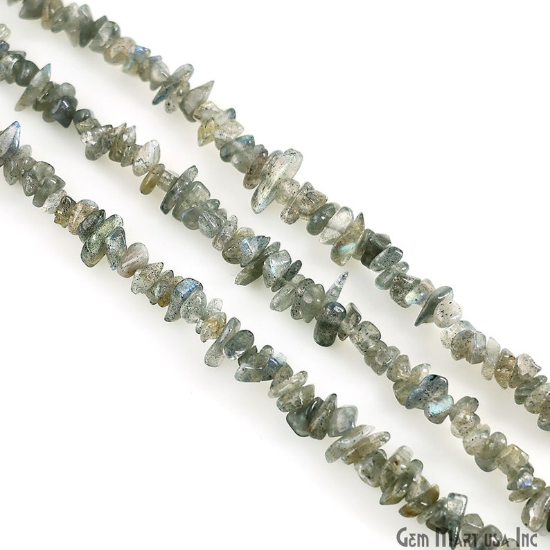 May include: A strand of grey and blue labradorite chip beads. The beads are irregular in shape and have a natural, rough texture.