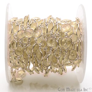 May include: A spool of silver chain with light yellow gemstone beads. The chain is made of small, round links and the beads are faceted and have a slightly irregular shape.