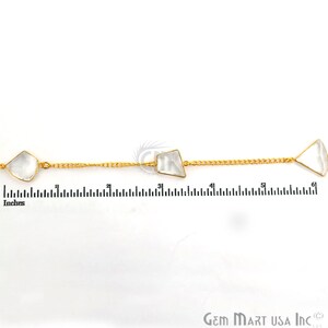 Pu&ograve; includere: Una catena d'oro con tre pietre di quarzo trasparenti. La catena &egrave; lunga 15,24 cm e ha un righello sullo sfondo come riferimento.