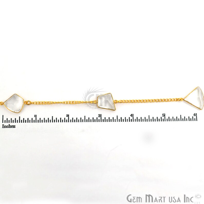 Pu&ograve; includere: Una catena d'oro con tre pietre di quarzo trasparenti. La catena &egrave; lunga 15,24 cm e ha un righello sullo sfondo come riferimento.