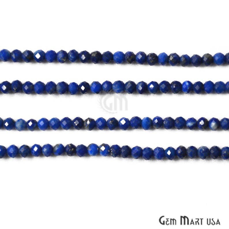 May include: A strand of faceted lapis lazuli beads, a deep blue color with flecks of gold pyrite. The beads are strung on a clear thread and are approximately 3mm in diameter.