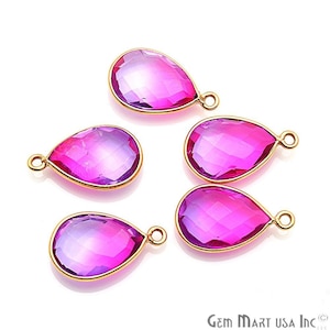 May include: Five pink teardrop-shaped gemstone pendants with gold-toned jump rings. The gemstones have a gradient of color from light pink to dark pink.